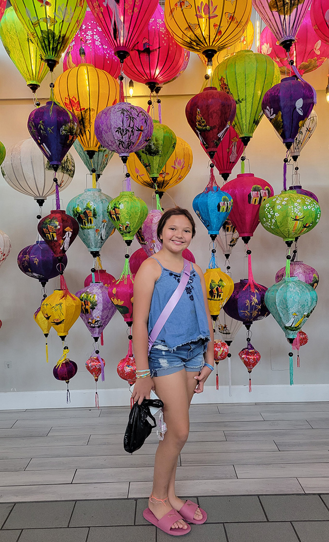 girl standing in front of vietnamese lanterns